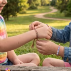 two friends exchanging friendship bands