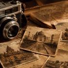 A vintage camera resting beside old sepia-toned photographs of India