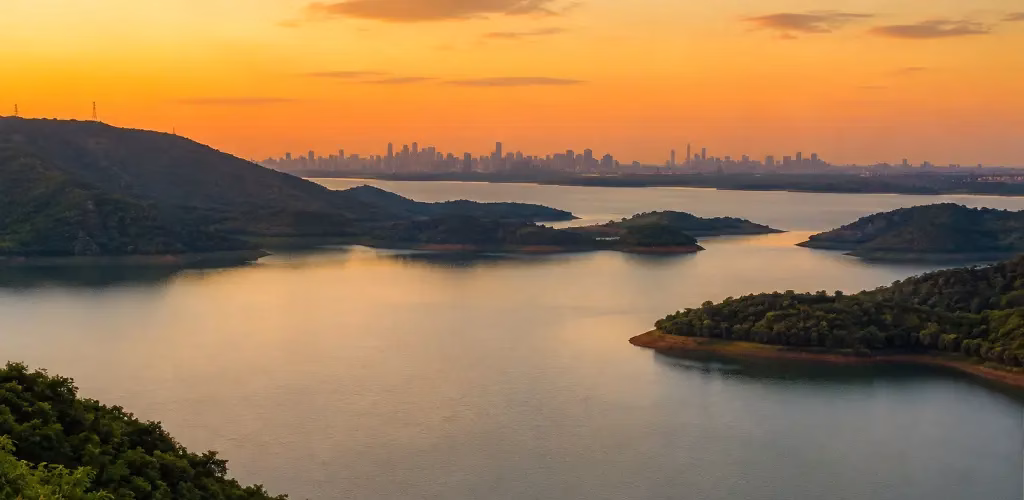 the Bhatsa dam reservoir with Mumbai's skyline visible in the distance