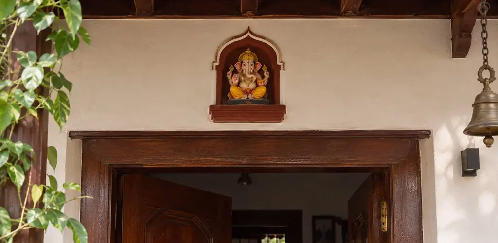 A small Ganesha figure fixed permanently above a home's entrance
