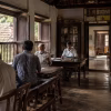 An old village reading room in Kerala, with people gathered around newspapers and books