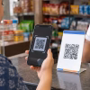 A customer scanning a UPI QR code at a shop counter